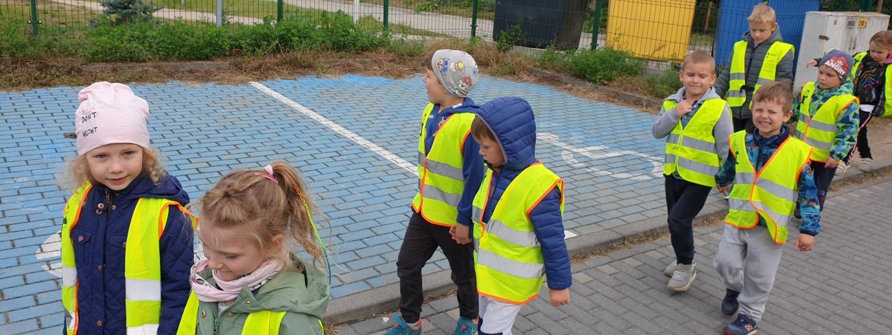 Grupa przedszkolaków ubrana w odblaskowe kamizelki